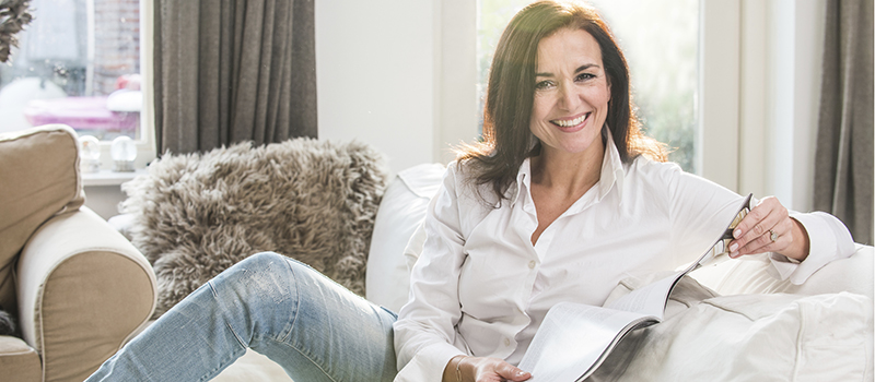 Woman reading a magazine smiling at the camera